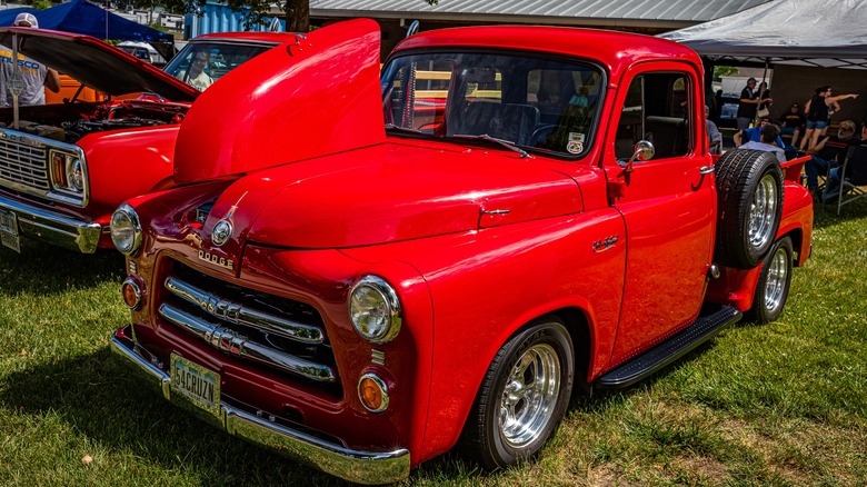 A red 1954 Dodge C1 truck at an auto show