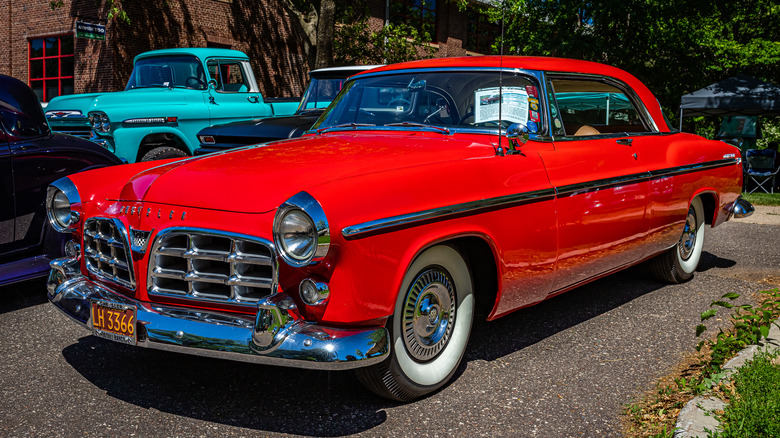 A red 1955 Chrysler C300 at an auto show