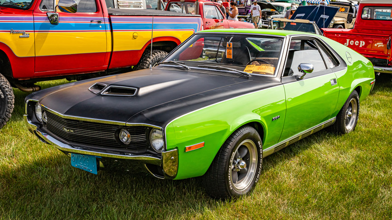 Green and black 1970 AMC AMX parked on grass