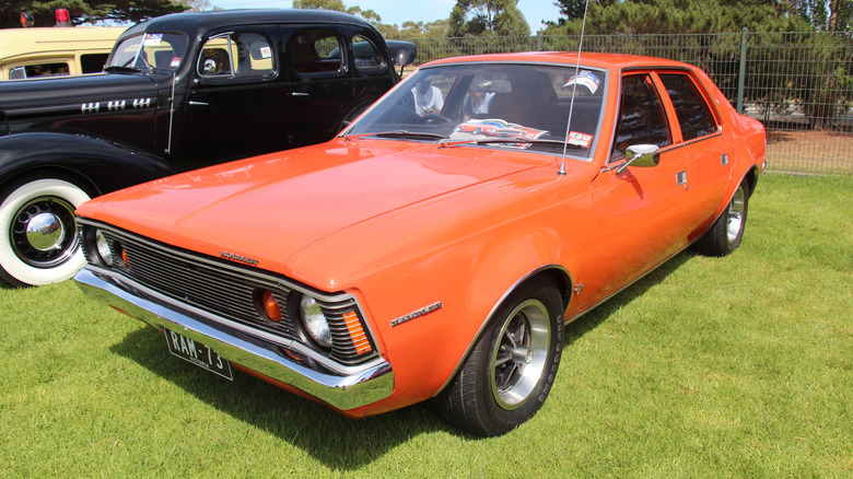 Orange 1973 AMC Hornet sedan parked on grass