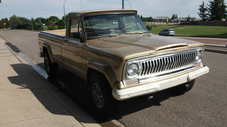 Beige 1974 Jeep J-20 pickup parked at roadside