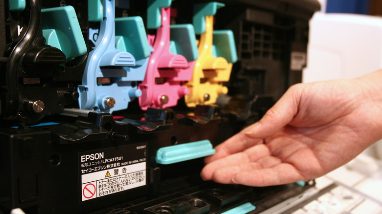 hand reaching inside a printer 