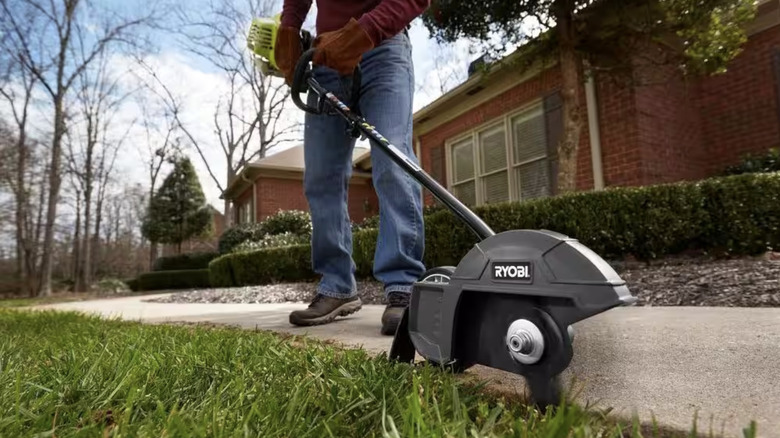 Man using edger to clean up yard