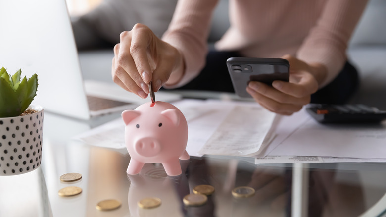 Person putting money in piggy bank