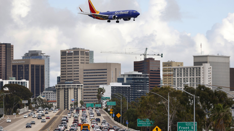 Boeing 737 flies above busy road