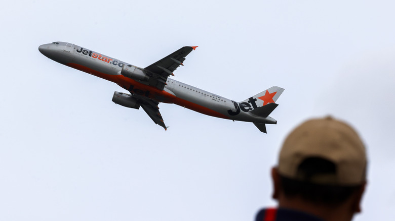 Person watches Airbus A321 taking off