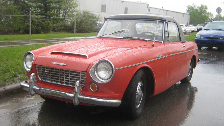 Red Fairlady 1500 parked on the street in the rain