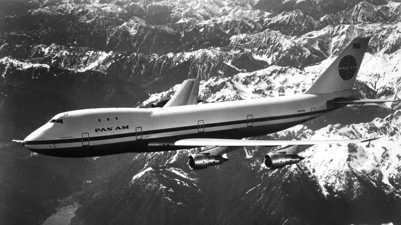 A PanAm Boeing 747 flying atop mountains.