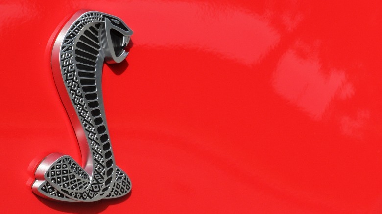 Close-up of a Shelby Cobra logo on a red background