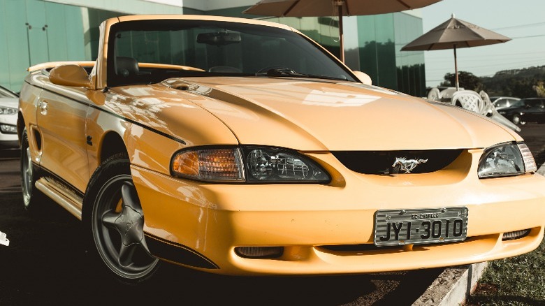 A yellow convertible SN95 Mustang