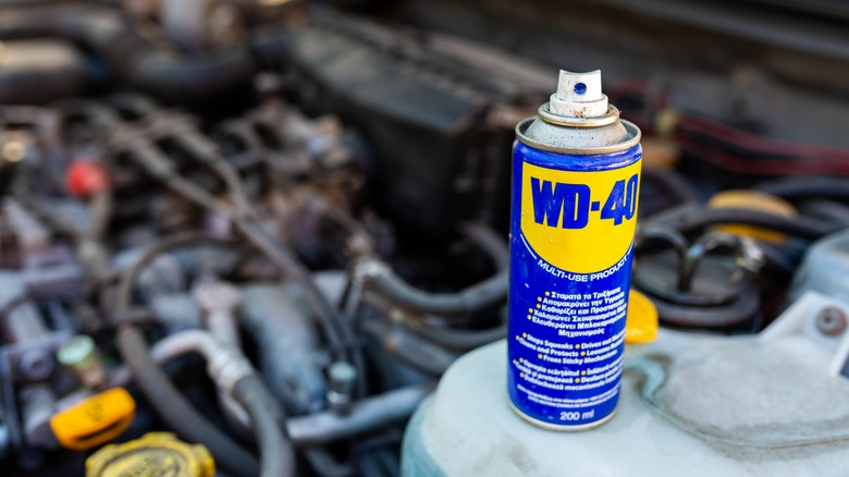 WD-40 can in front of car engine