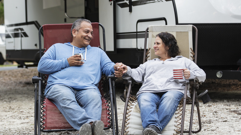 couple sitting in front of camper