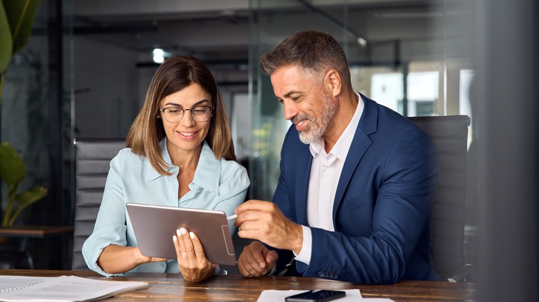 two persons looking at a tablet