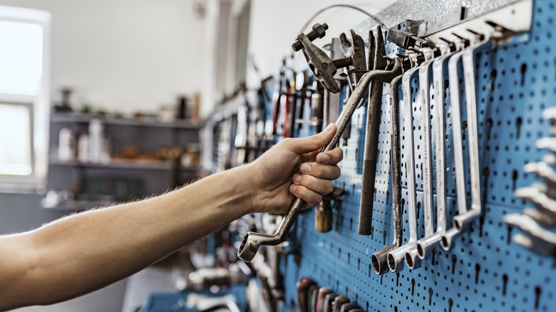 hand reaching for wrench