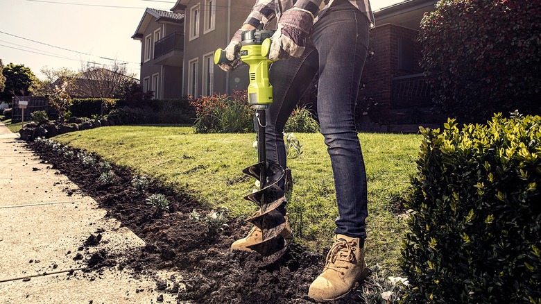 Person using Ryobi auger