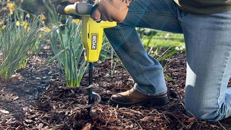 Person using Ryobi auger