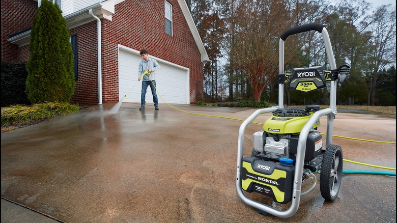 Man using Ryobi Pressure Washer on driveway 