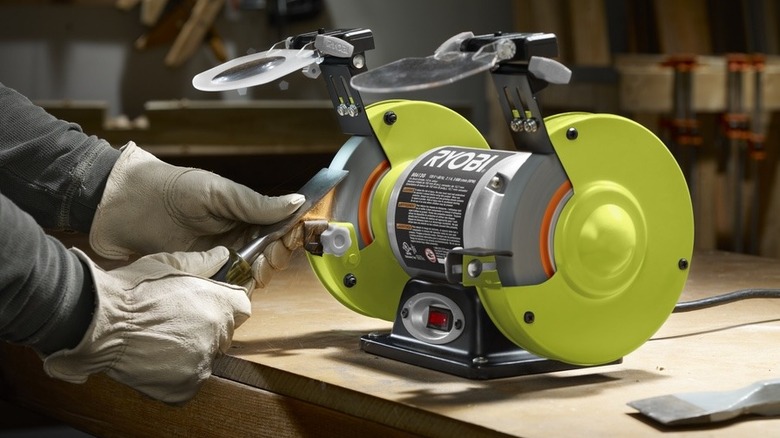 person using Ryobi Bench Grinder