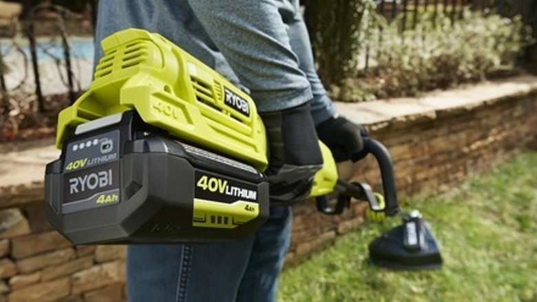 Person using Ryobi string trimmer