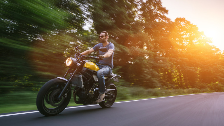 man riding scrambler on road