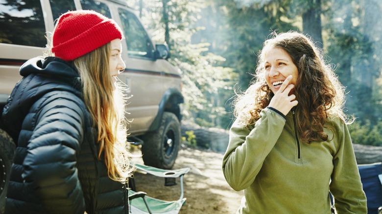 Two smiling women at a campsite