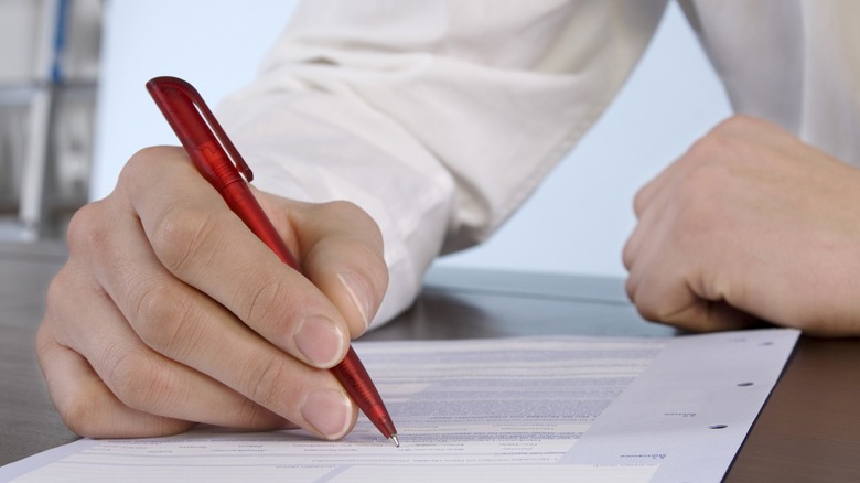 Man filling form with red pen