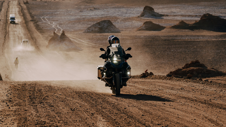 Couple riding an adventure bike across the desert