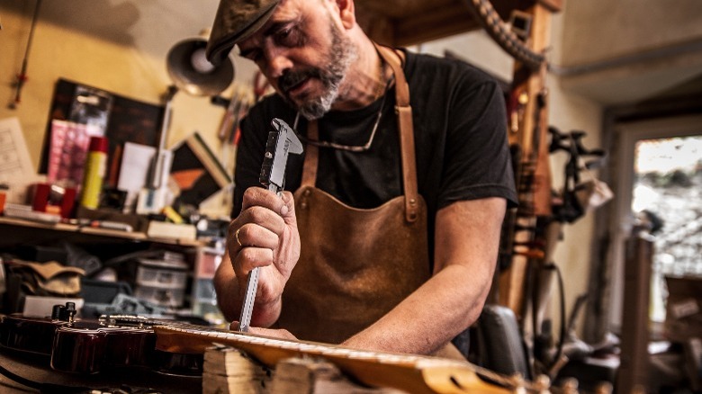 Picture of a luthier working on an electric guitar.