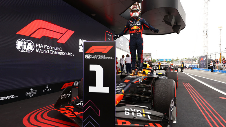 Max  Verstappen standing on car celebrating after 2023 Spanish Grand Prix win