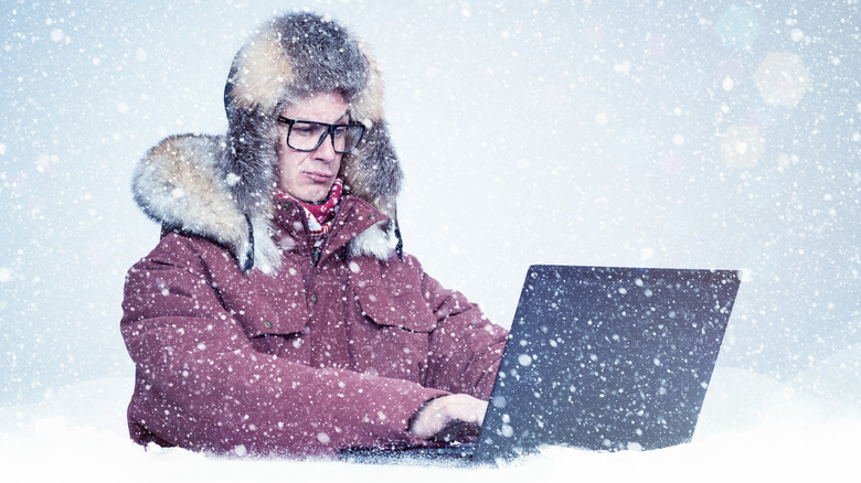 person using laptop in snow