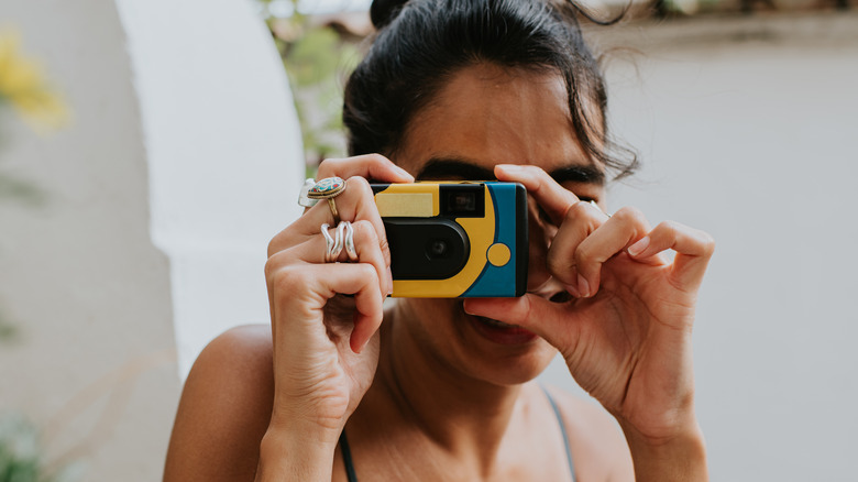 Woman using disposable camera