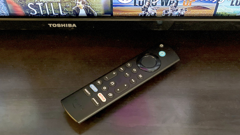 Fire TV Stick 4K Max (2nd Gen) remote in front of Toshiba brand TV