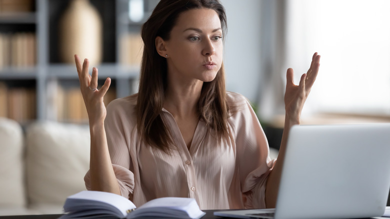 person looking frustrated front of laptop