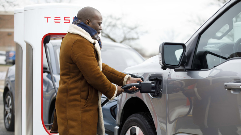 Person charging using Tesla Supercharger