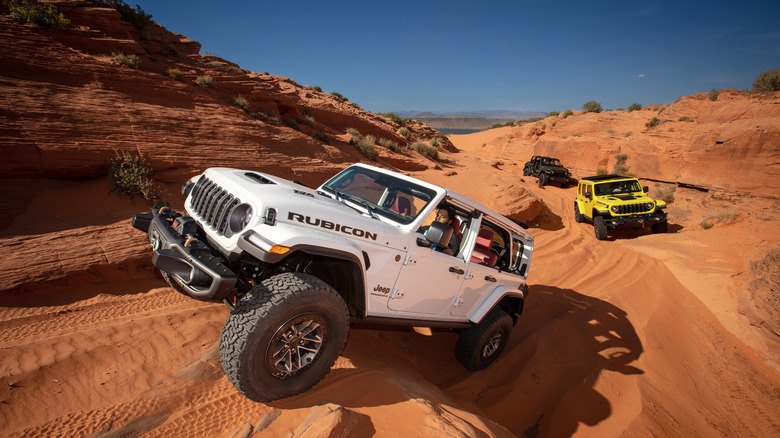 front view of the white Jeep Wrangler climbing a rock