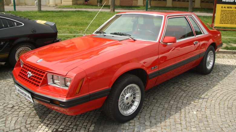 Red 1979 Ford Mustang parked on cobbles