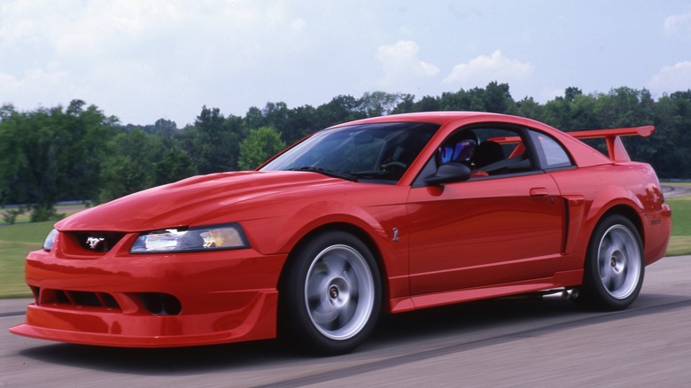 One of 300 total Performance Red 2000 Ford SVT Mustang Cobra R models speeding past the camera.