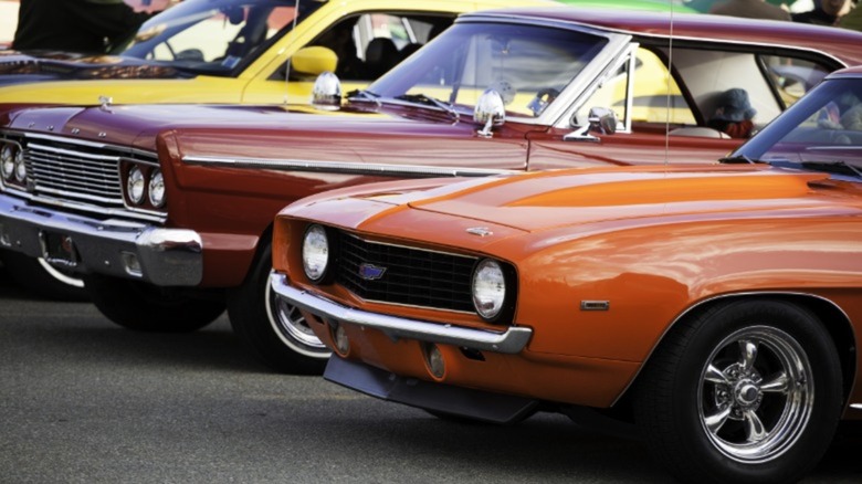 a classic ford and cheverolet car parked next to each other