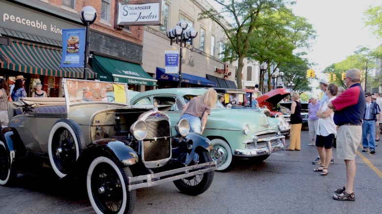 Ford Model A and 1950 Chevrolet 2d Deluxe parked on street at car show