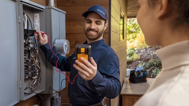 A sunrun employee working on a breaker board