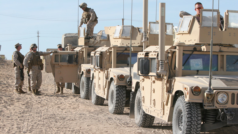 Troops deploying from a convoy of Humvees