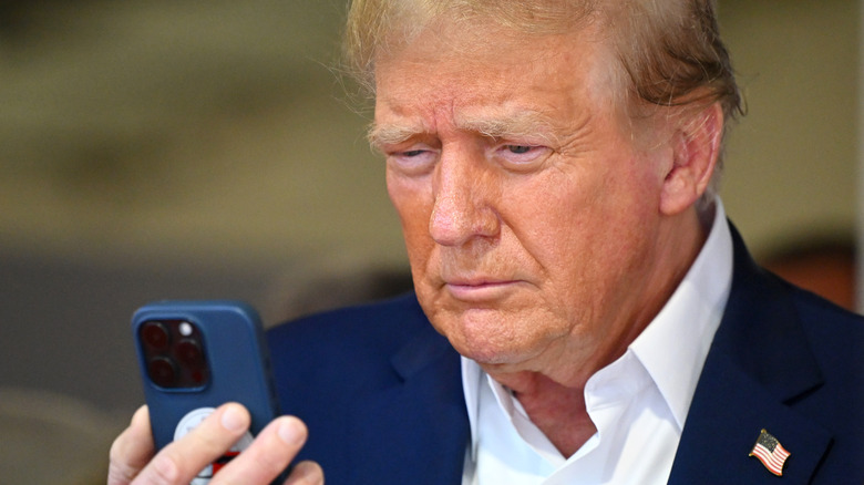 Donald Trump talks on the phone in the McLaren garage prior to the F1 Grand Prix of Miami at Miami International Autodrome on May 05, 2024 in Miami, Florida.