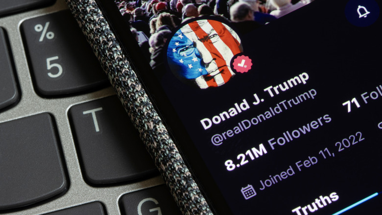 Cellphone resting on a computer keyboard showing President Donald Trump's X (formerly Twitter) account