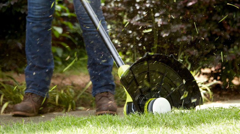 person using Ryobi 18V One+ string trimmer