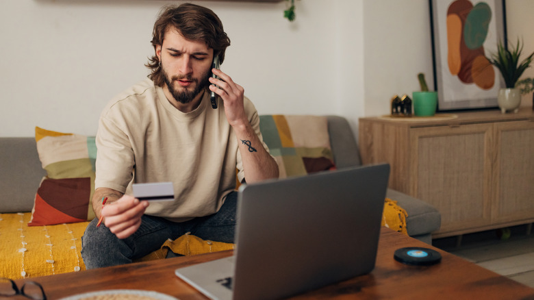 person on phone holding credit card