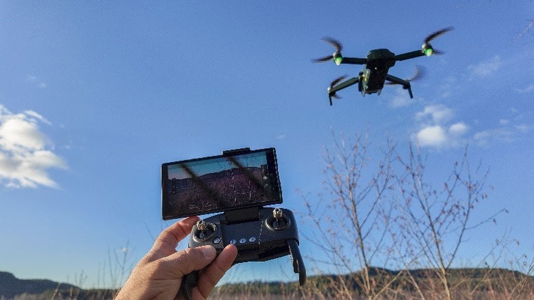 Hand holding controller, drone nearby