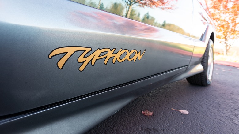 Yellow "Typhoon" lettering is pictured on the side of a metallic green 1993 GMC Typhoon.