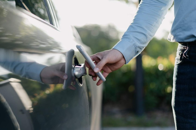 Businessman unlocking car with phone