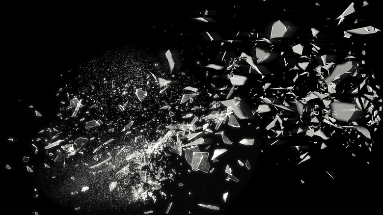 Glass pieces shattering on a black background