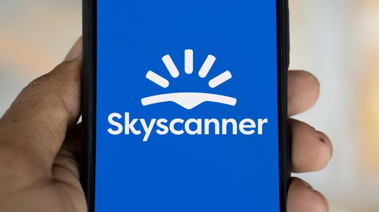 The Skyscanner app logo is shown on a mobile phone screen